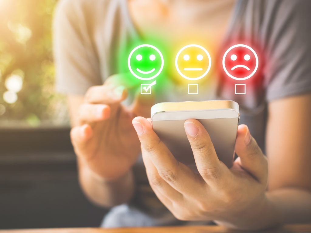 women checks happy face on a customer Service Experience survey
